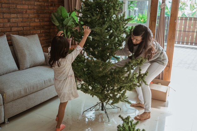 Happy Asian mother and daughter decorating the Christmas tree