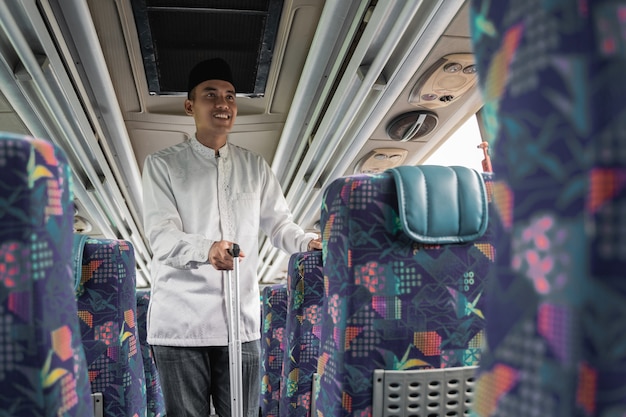 Happy asian muslim man doing traveling back to his hometown by riding a bus