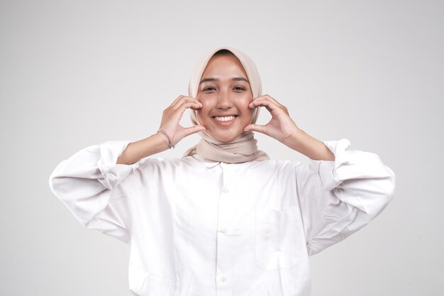 Foto felice muslimah asiatico in posa davanti alla telecamera isolato su sfondo bianco