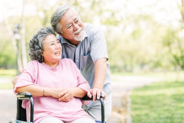 Happy Asian senior couple smiling outside 