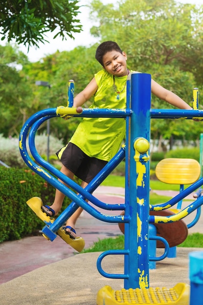 Happy asian sport boy play on swing playground in garden