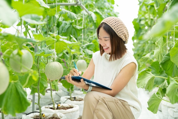 달콤한 멜론 멜론 농장에서 행복한 아시아 학생 여자 연구 기술 컴퓨터 및 데이터