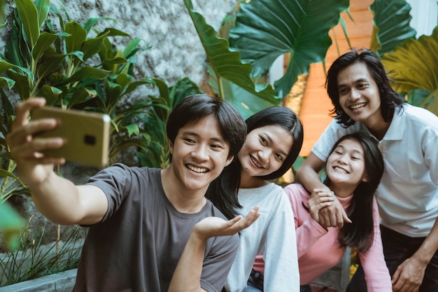 Happy asian teenages with smartphone photographing at cafe when hanging out