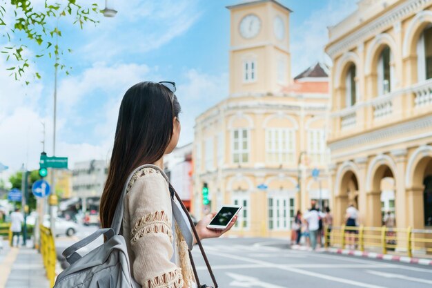 Photo happy asian traveler woman walking on phuket thailand old town and looking at sino portuguese architecture building travel concept