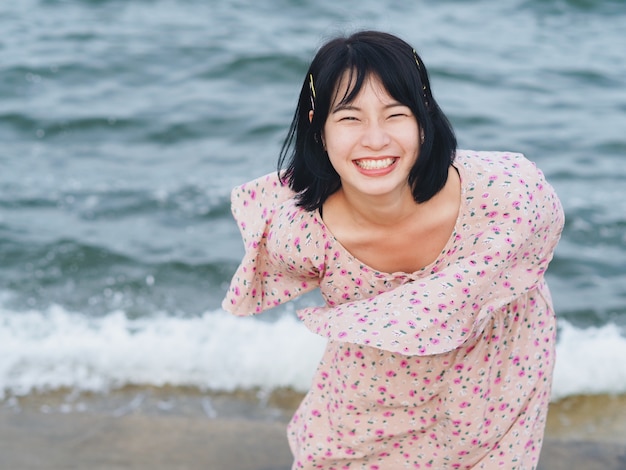 海沿いの幸せなアジア女。