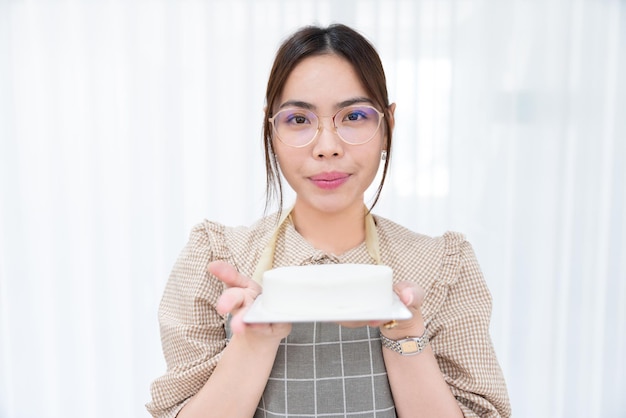 写真 幸せなアジア人女性シェフ甘いデザートケーキを作るベーカリーを焼く ベーカリーからキッチンレストランへ