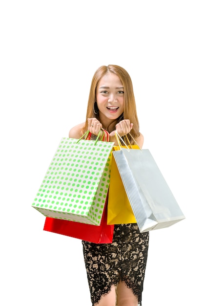 Happy asian woman in dress holding shopping bags