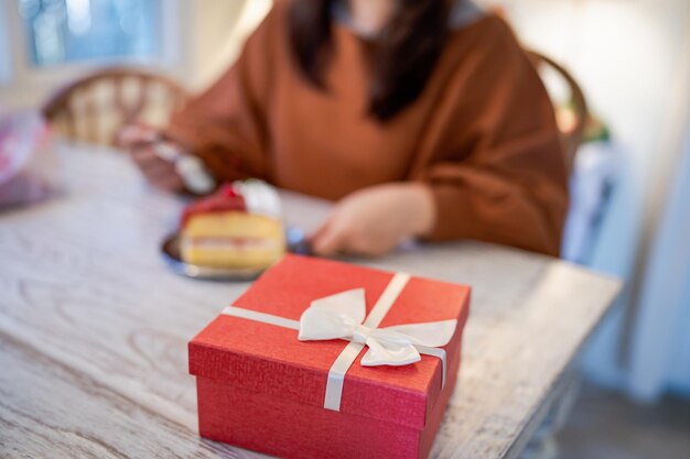 Happy Asian woman eating tasty Christmas fruit cake Christmas Dinner Party with delicious piece of xmas cake New Year and Christmas concept