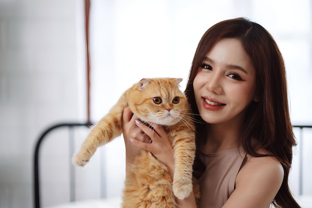 행복한 아시아 여성 소유자 귀여운 고양이 가정에서 장난스러운 애완동물과 인간의 생활 방식의 우정
