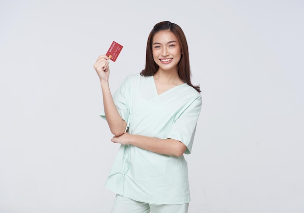 Happy asian woman patient showing credit card isolated on white background