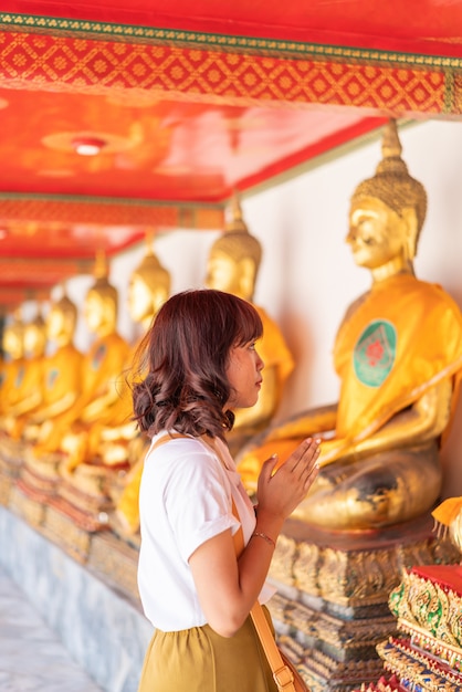 Happy Asian Woman Praying with Buddha