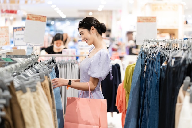 Счастливая азиатка делает покупки в торговом центре