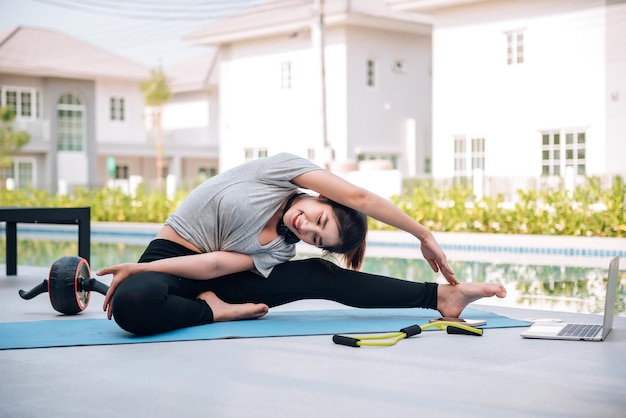 Happy asian woman stretching exercise and yoga workout in the morning at home outdoor