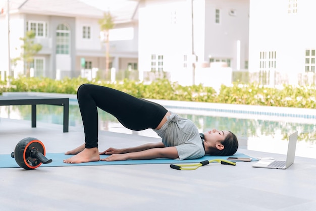 Happy asian woman stretching exercise and yoga workout in the morning at home outdoor