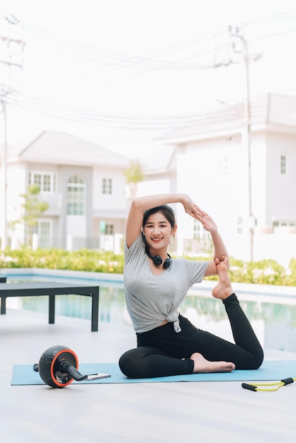 Happy asian woman stretching exercise and yoga workout in the morning at home