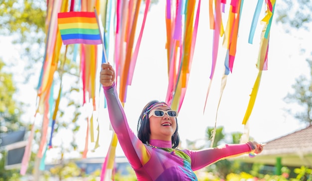 LGBTQ 또는 LGBTQIA의 레인보우와 함께 차 안에서 LGBT 프라이드 퍼레이드를 지원하는 행복한 아시아 여성