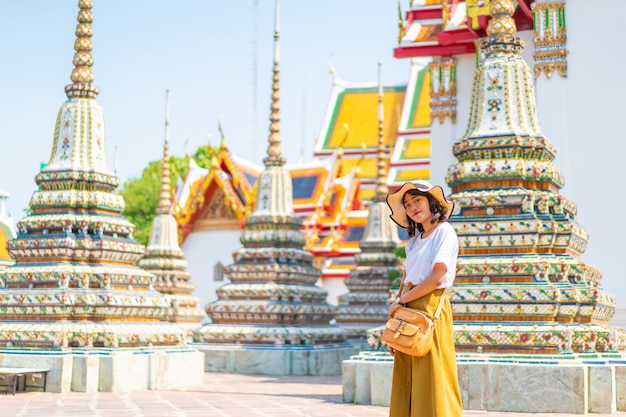 Viaggio asiatico felice della donna al tempio in tailandia