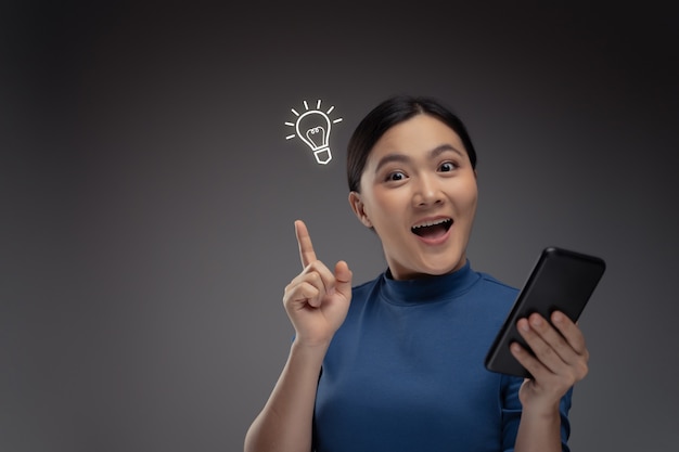 스마트 폰 및 아이콘 홀로그램 효과를 사용하여 행복 한 아시아 여자