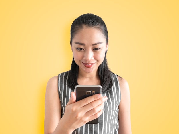 Happy Asian woman using smartphone and smile.