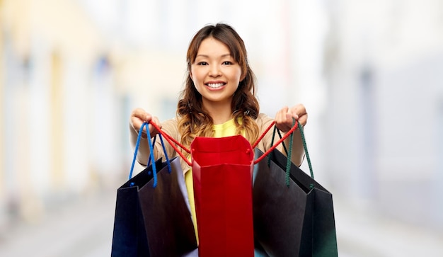 Photo happy asian woman with open shopping bags