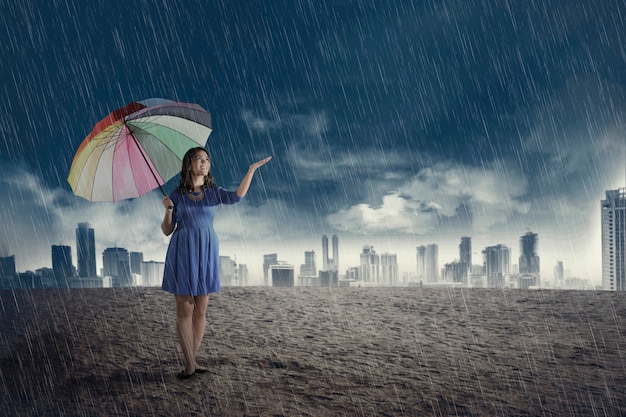 Happy asian woman with umbrella when rain 