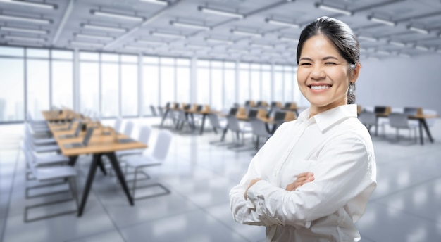 Happy asian worker arm crossed in office