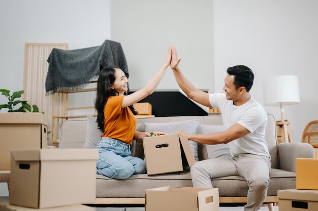 幸せな若いアジア人魅力的なカップル大きな箱を持った男と女新しい家カップルのための新しいアパート新しい家に引っ越す 引っ越し家