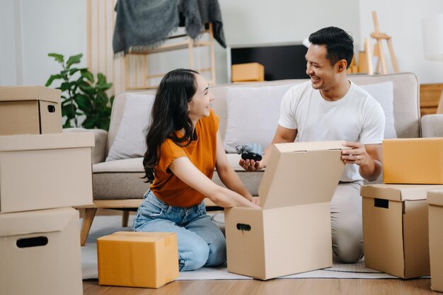 幸せな若いアジア人魅力的なカップル大きな箱を持った男と女新しい家カップルのための新しいアパート新しい家に引っ越す 引っ越し家