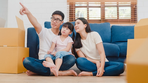 Happy asian young family homeowners in new house