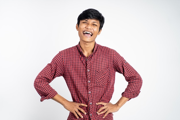 Happy asian young man laughing naturally on studio background