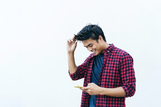 Happy asian young man using mobile phone outdoor asian social\
influencer having fun with new trends smartphone apps generation z\
media technology and youth millennial people lifestyle