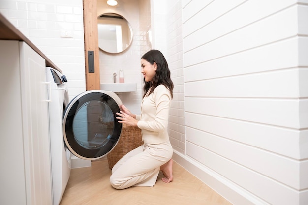 Happy Asian young woman is doing laundry in home healthy lifestyle concept