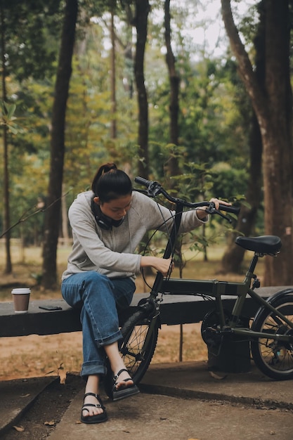 Happy Asian young woman walk and ride bicycle in park street city her smiling using bike of transportation ECO friendly People lifestyle concept