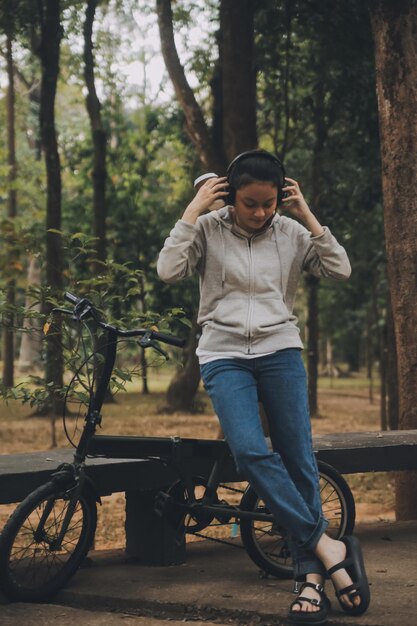 Happy Asian young woman walk and ride bicycle in park street city her smiling using bike of transportation ECO friendly People lifestyle concept