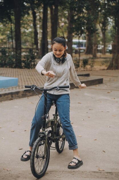 Happy Asian young woman walk and ride bicycle in park street city her smiling using bike of transportation ECO friendly People lifestyle concept