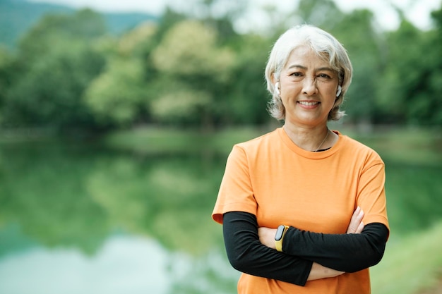 Happy athletic Senior woman checking her smartwatch in the park