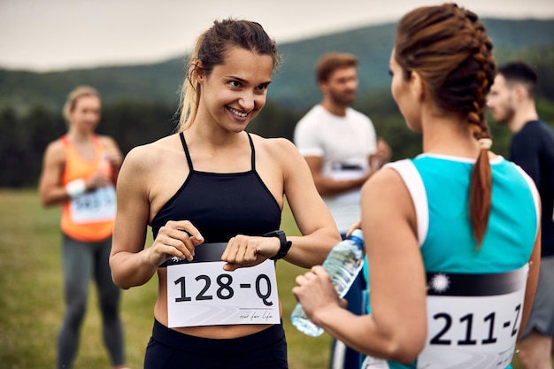 자연에서 마라톤 경주를 준비하는 동안 친구와 의사 소통하는 행복한 운동 여성
