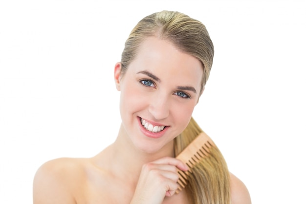 Happy attractive blonde combing her hair