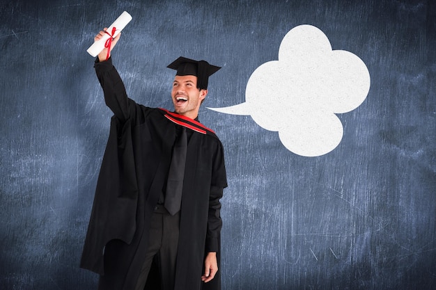 Photo happy attractive boy after his graduation against blue chalkboard