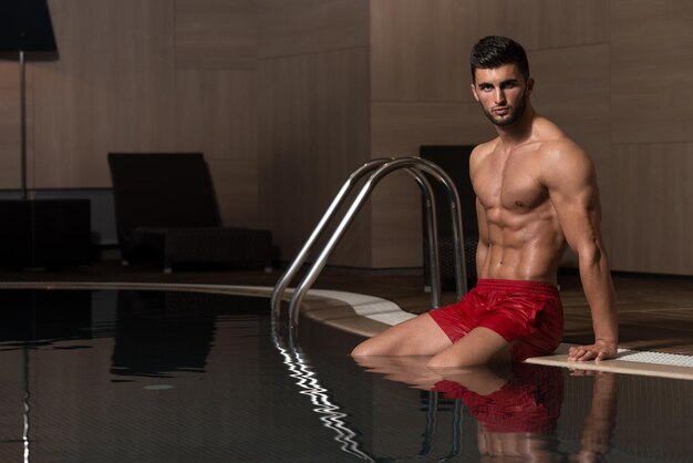 Happy Attractive Man Resting Relaxed On Edge Of Swimming Pool