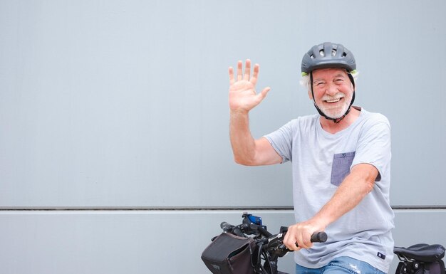 Happy attractive retired senior man with helmet enjoying sport\
activity with electric bicycle in outdoors sustainable mobility\
concept