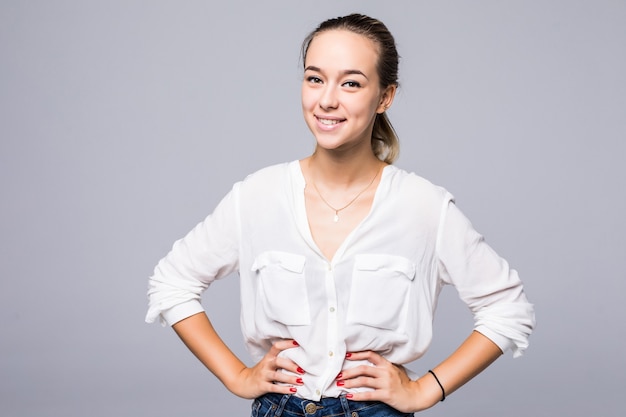 Happy attractive woman standing over gray wall