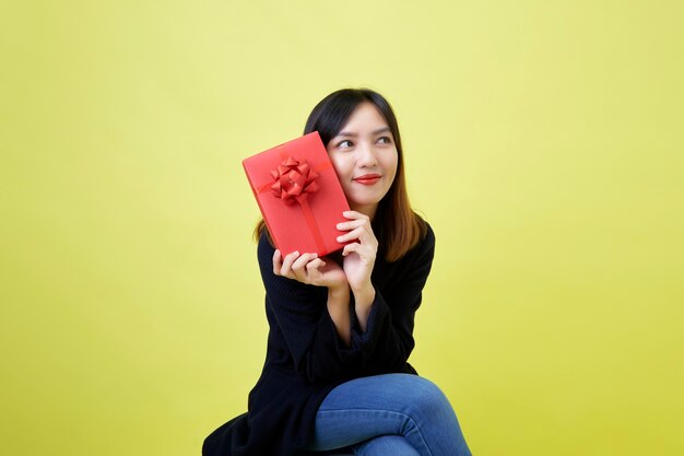 Happy attractive young woman holding red gift box