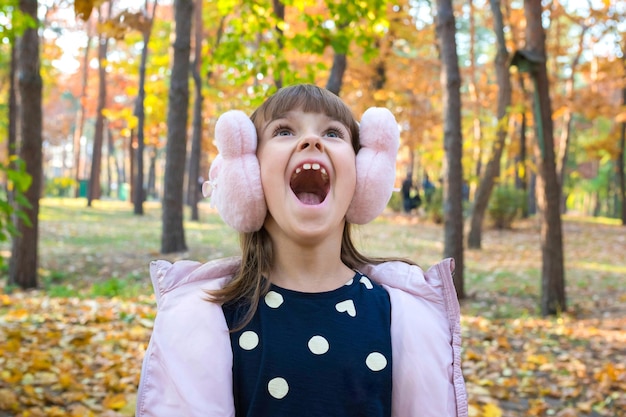 Happy autumn outdoor portrait of a girl in the park on a sunny day