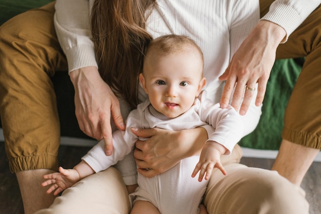 Happy baby boy in the arms of his parents