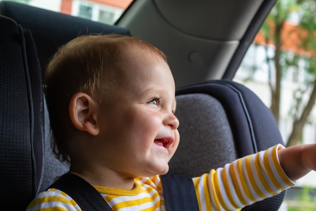 Foto felice bambino seduto nel seggiolino auto