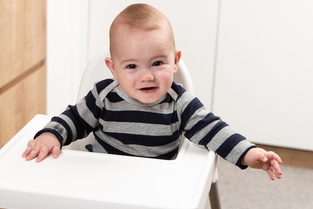 Happy Baby Boy Sitting in High Chair