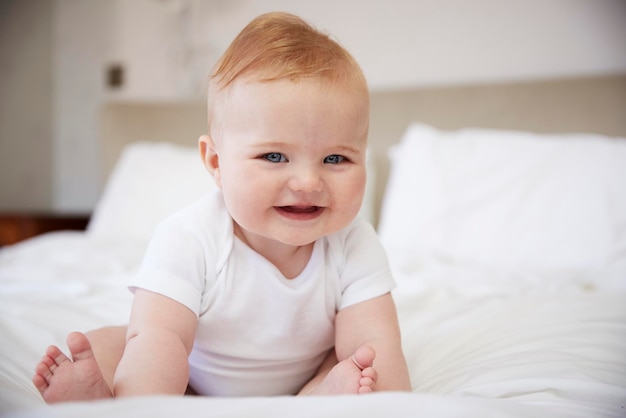 両親のベッドに座っている幸せな男の子