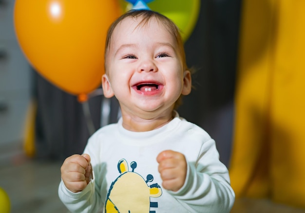 風船の束を持つ幸せな男の子 最初の誕生日の男の子のパーティー