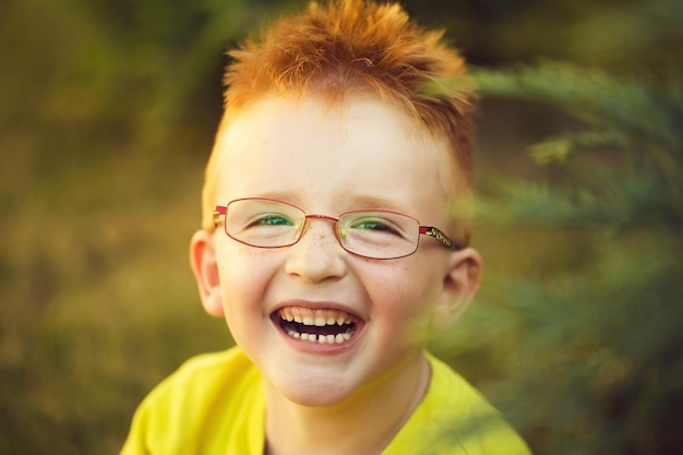 Happy baby boy with red hair in glasses